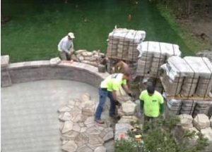 Workers building a large stone patio