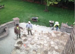 Workers building a large stone patio
