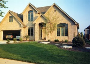 lawn and driveway outside of a stone house