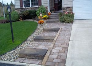 paver walkway next to driveway leading to front door