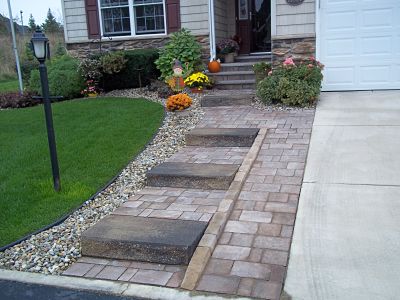 paver walkway next to driveway leading to front door