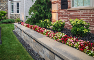 Retaining wall designed with rock border, and flowerbed